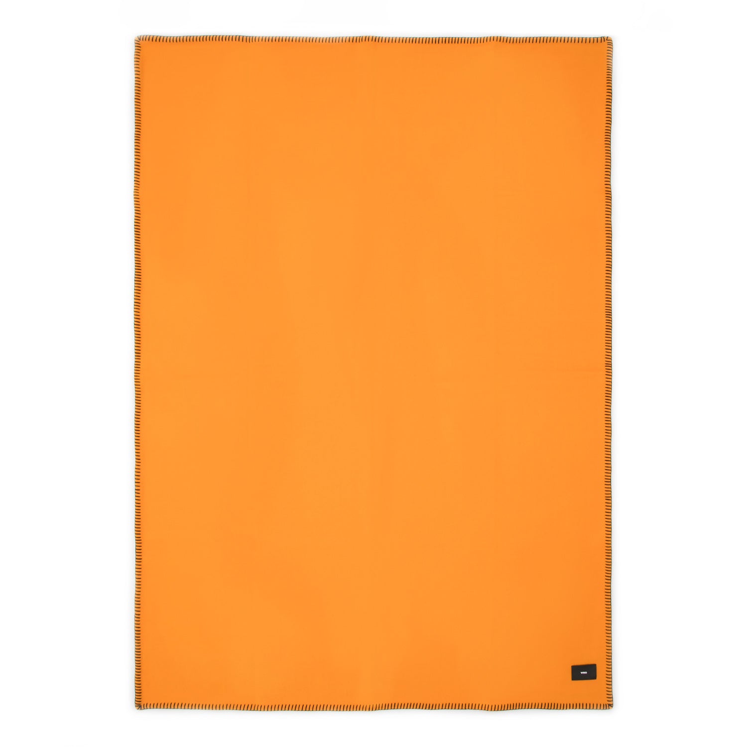A flat orange Merino wool blanket with black contrast stitching and a tag visible on the lower side.