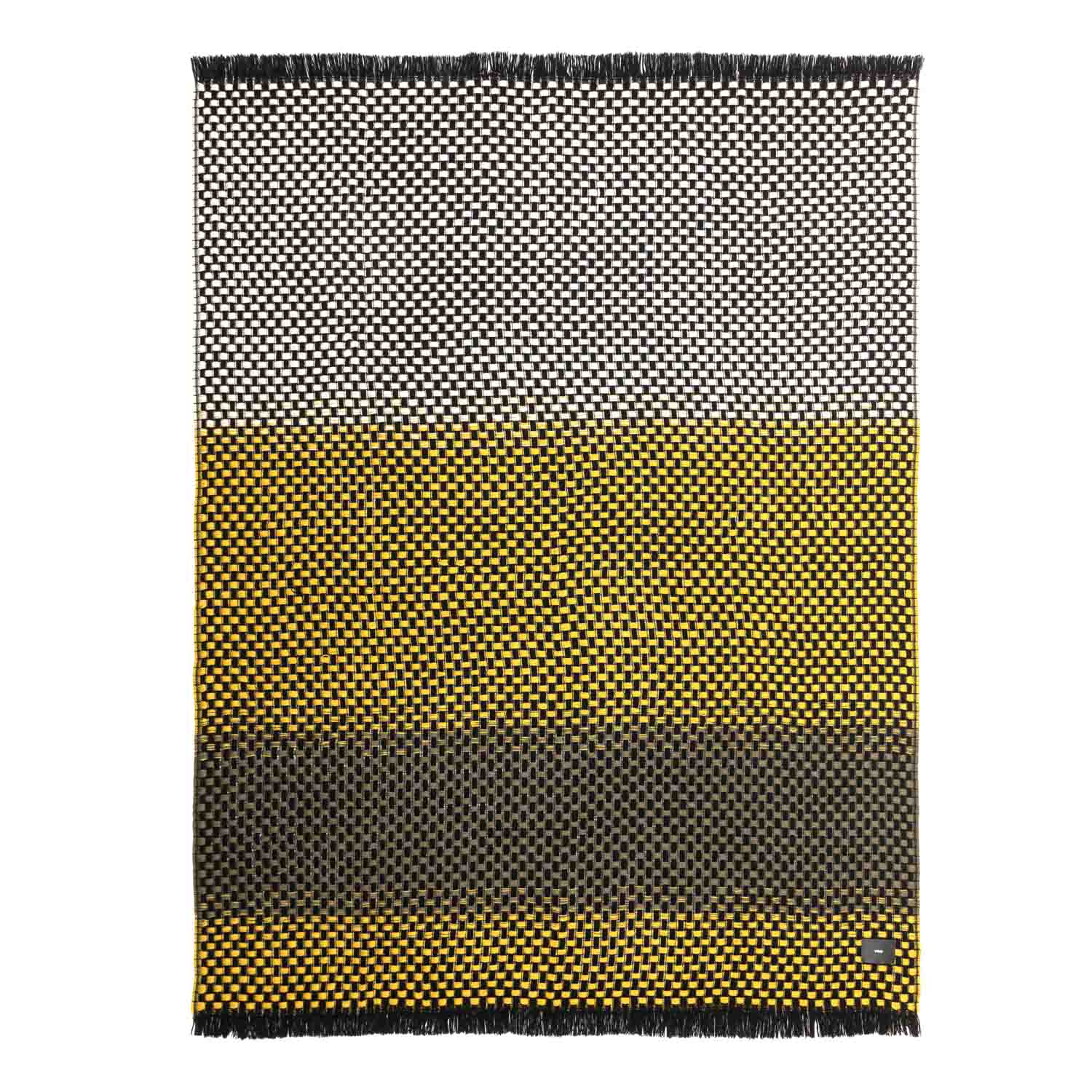 A folded blanket with a geometric pattern in shades of black, white, mustard, and brown, finished with twisted fringe.