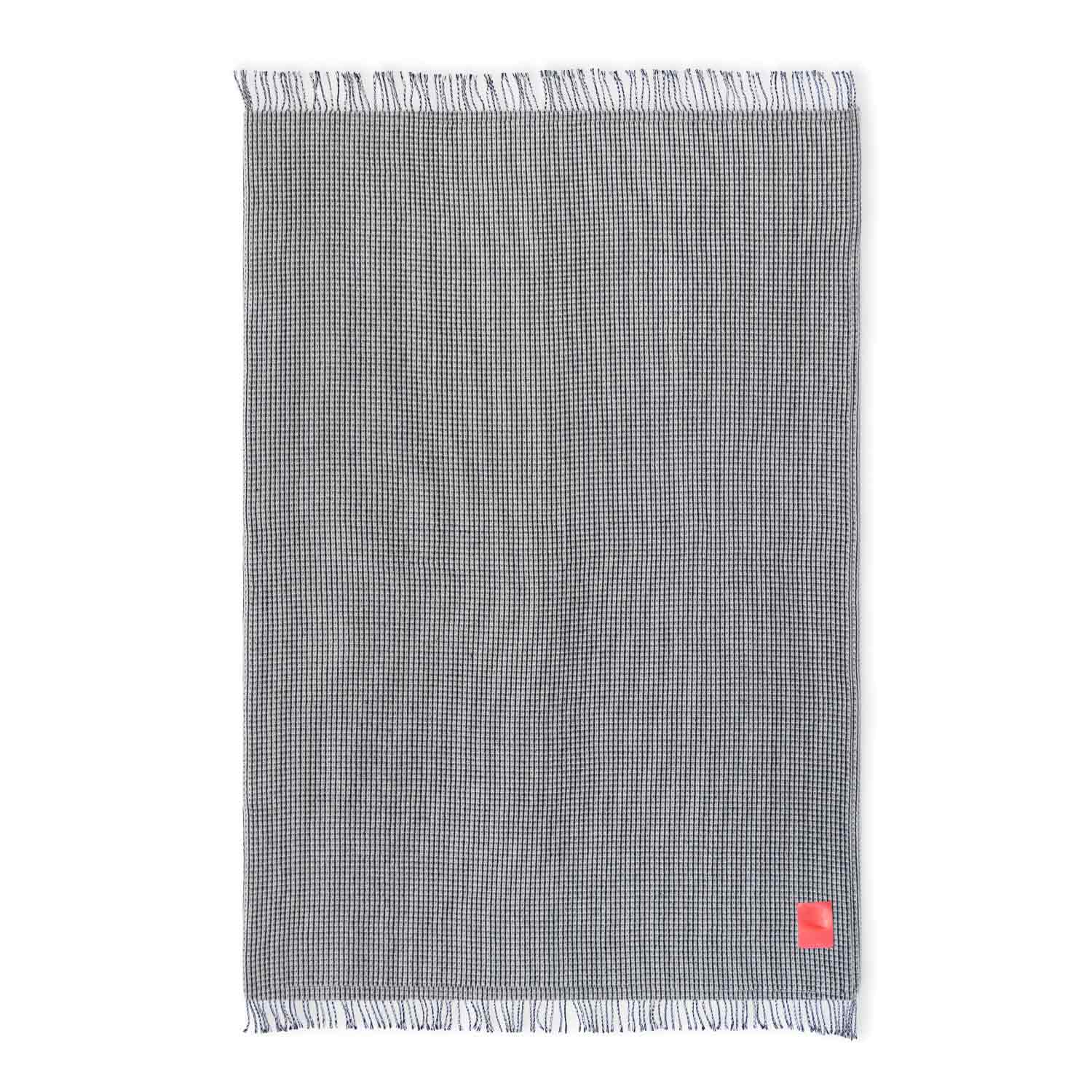 Black and white honeycomb wool blanket with red leather patch on a white background