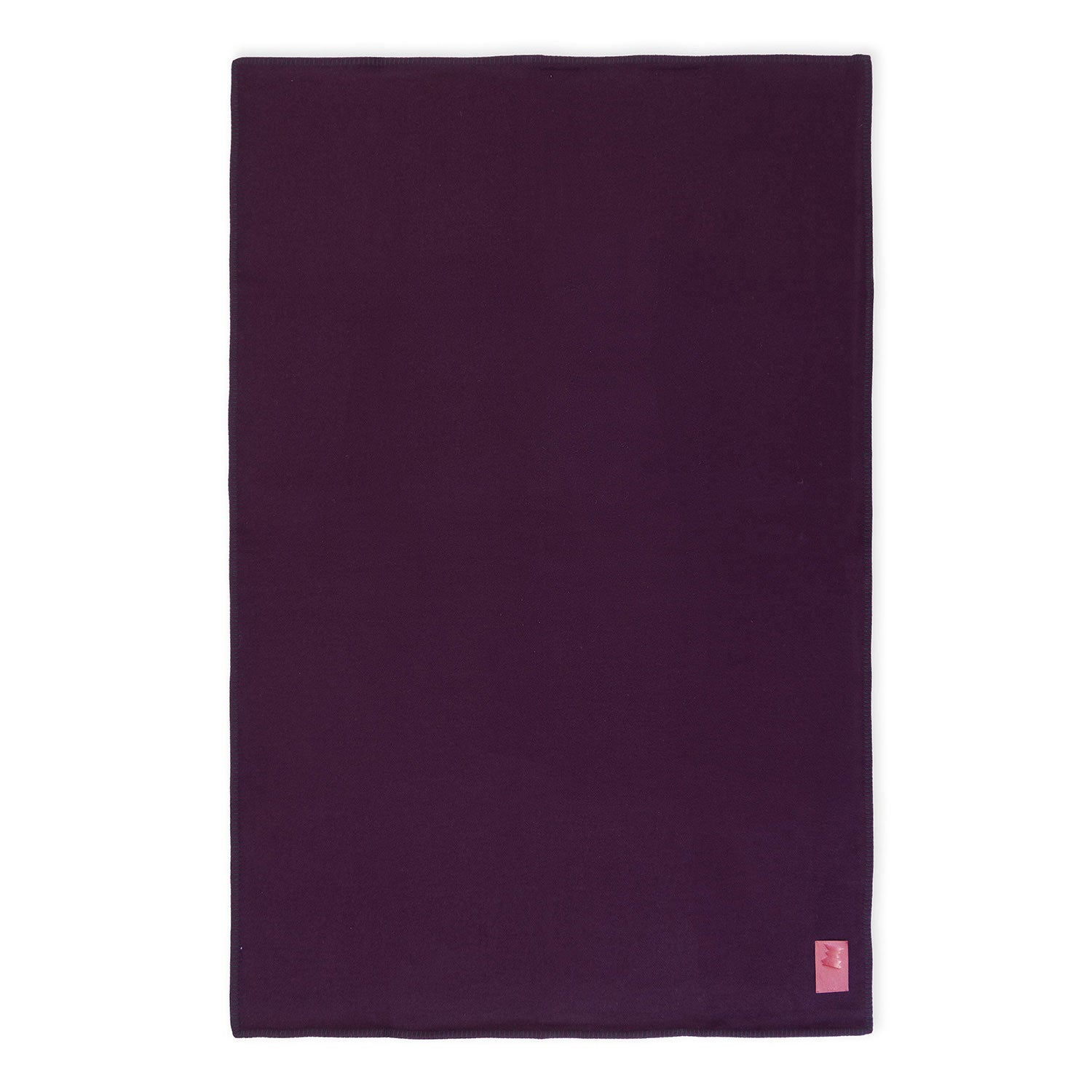 A flat bordeaux purple merino wool blanket with a visible brand tag.