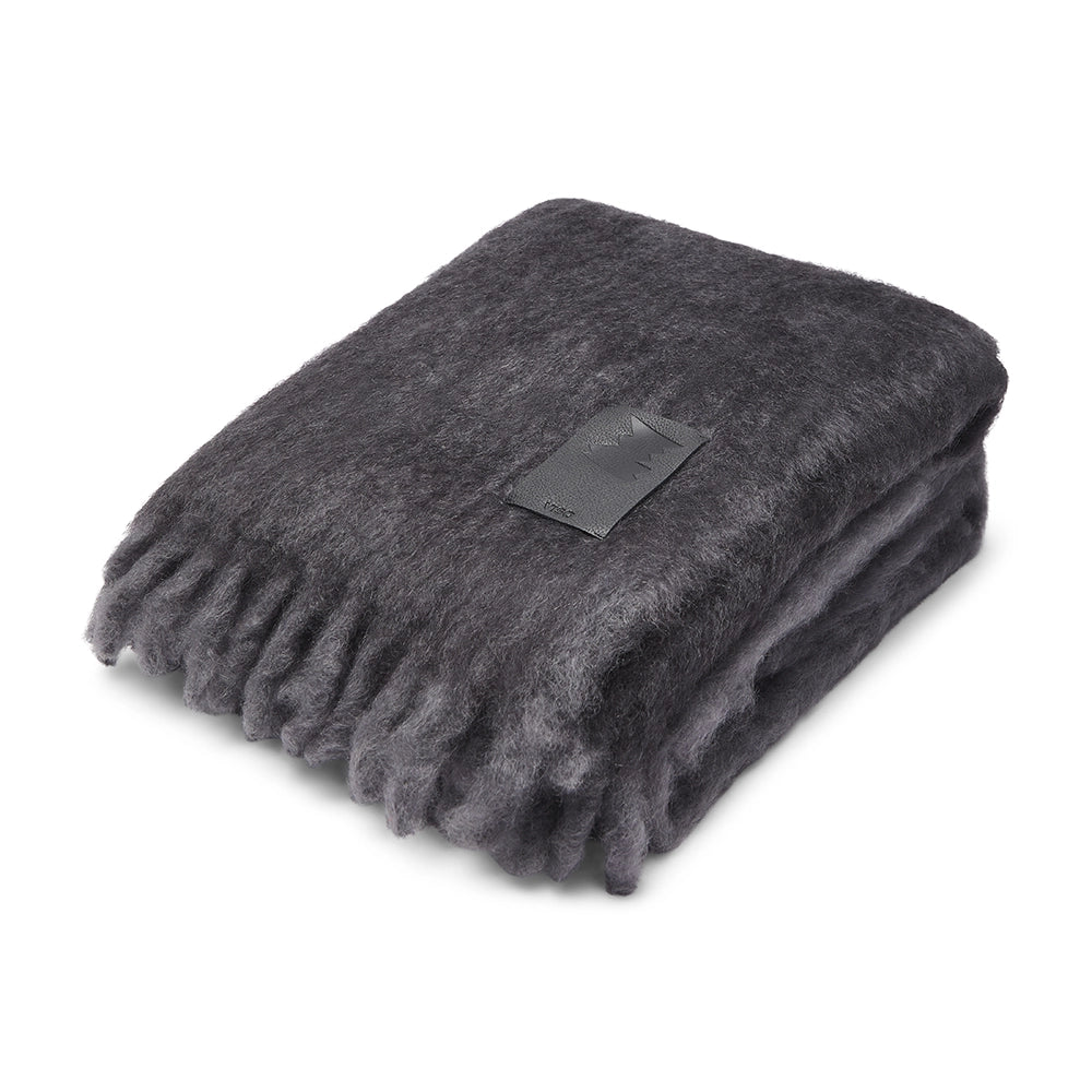 Folded dark gray blanket with a label on a white background