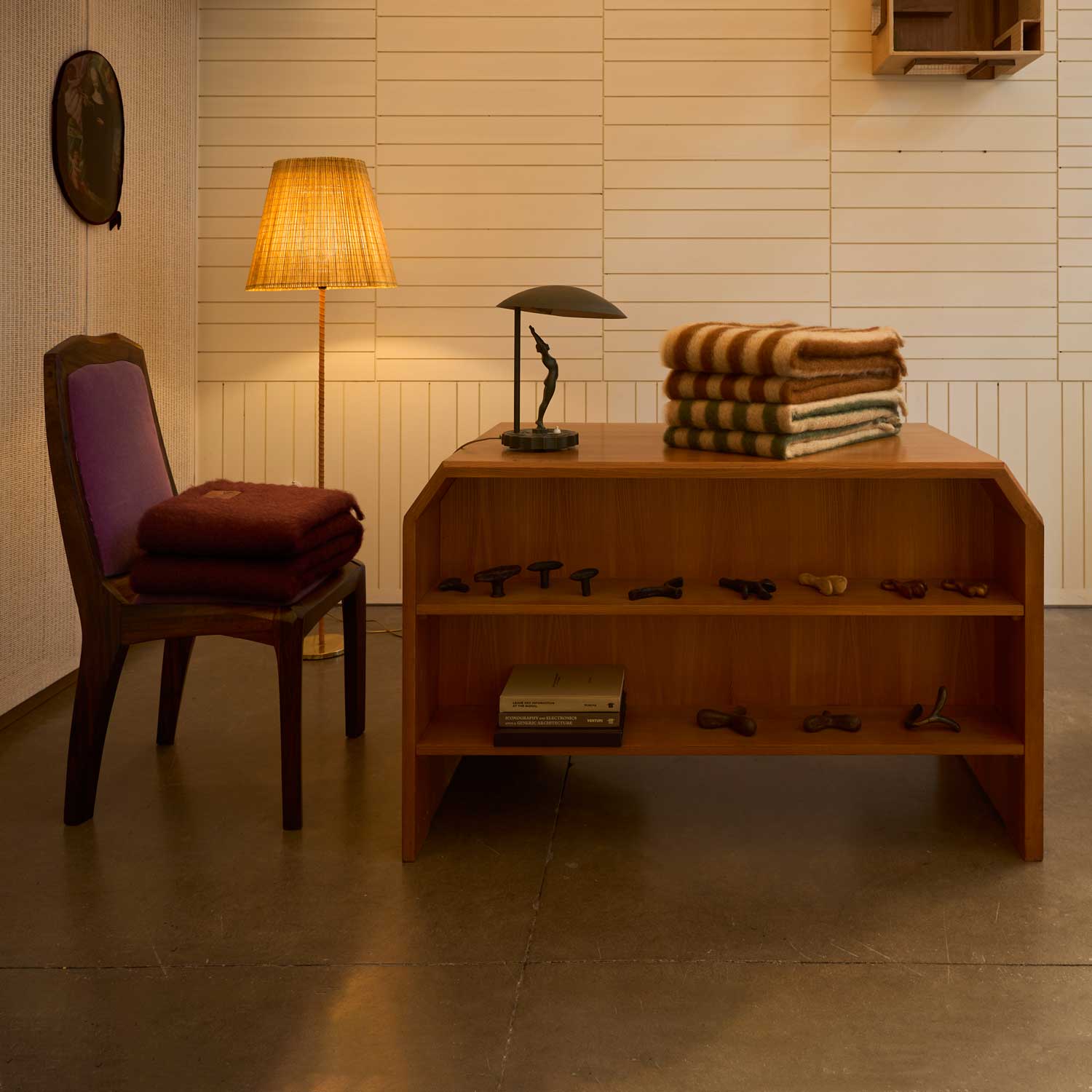 A chair and table in a room, with some mohair blankets draped over them.