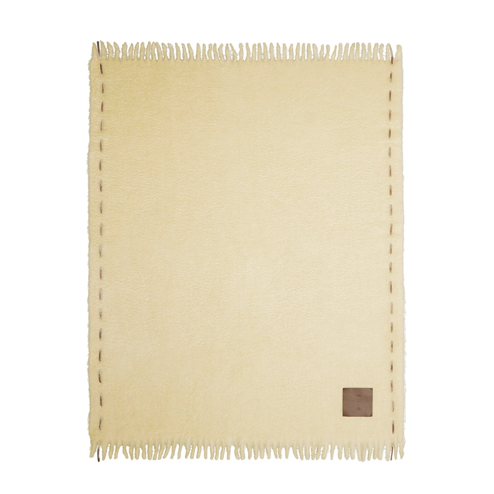 Butter color mohair blanket with a chocolate label and stitching on a white background – Ready to Hang X Viso Project