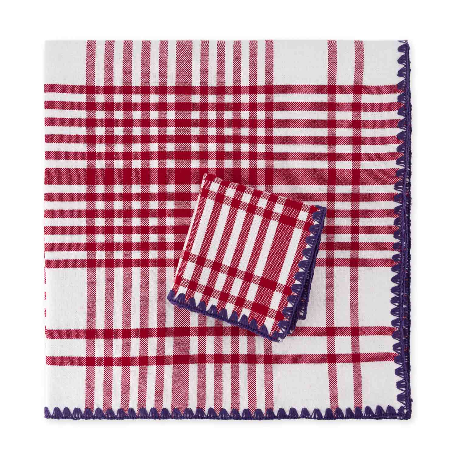 A folded cotton check jacquard tablecloth and napkin featuring a red and purple plaid pattern with contrasting detail stitching.