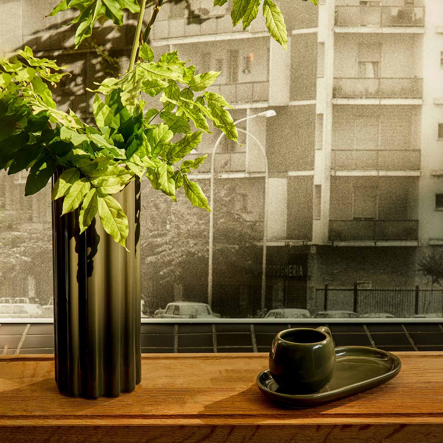 A vase and coffee set in green ceramic in a kitchen.