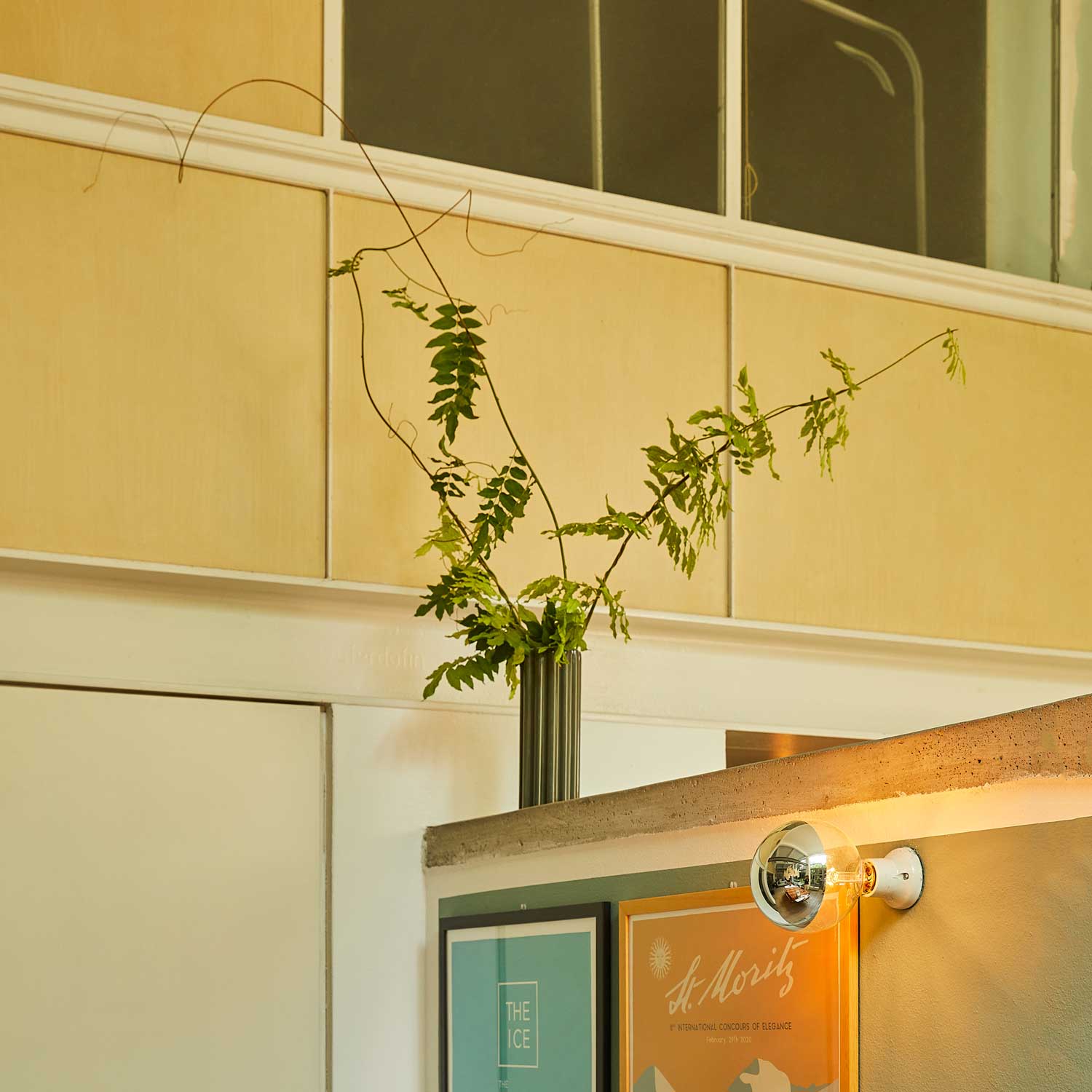 A living room with a green ceramic vase.