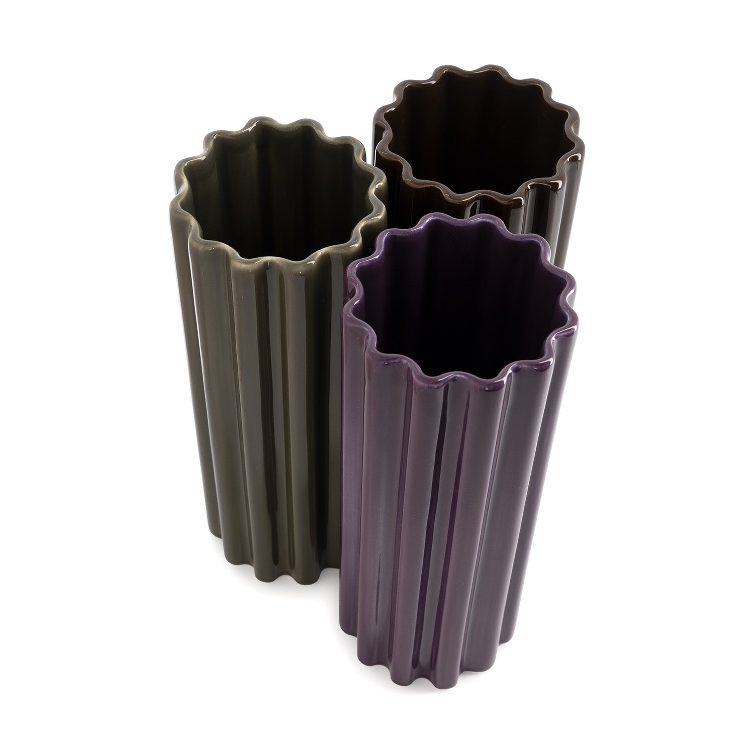 Three high-gloss ceramic vase in purple, green and brown,  with a ribbed design, standing against a white background.