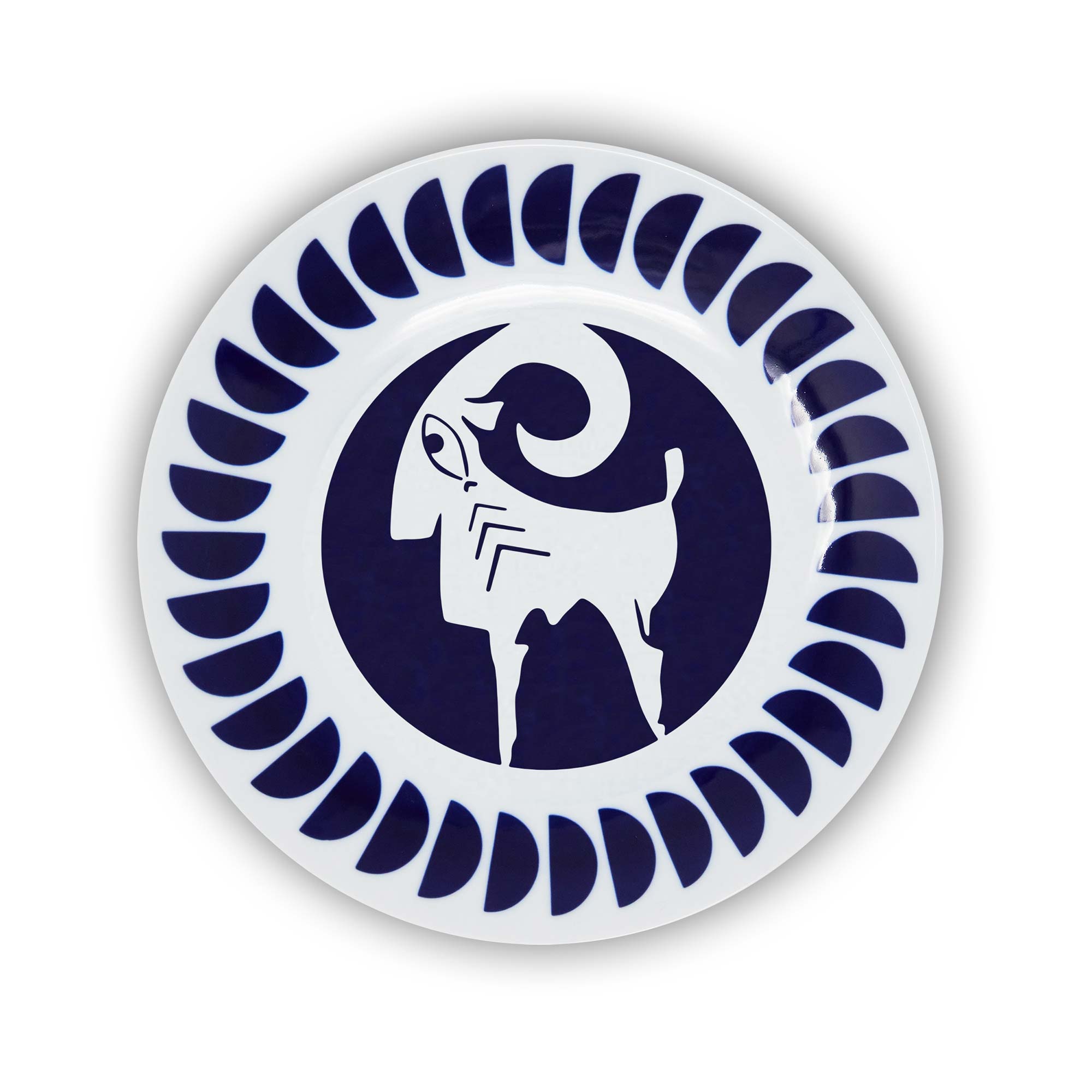 A round porcelain plate with a navy and white design featuring an illustration of the Aries sign of the zodiac.