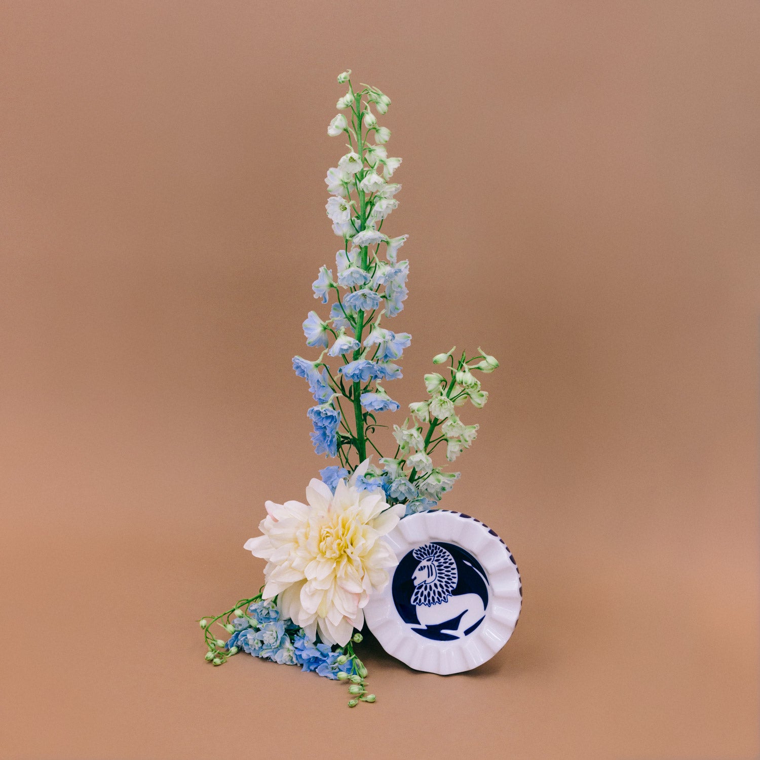 A white and navy porcelain valet tray, set on a base and decorated with flowers.