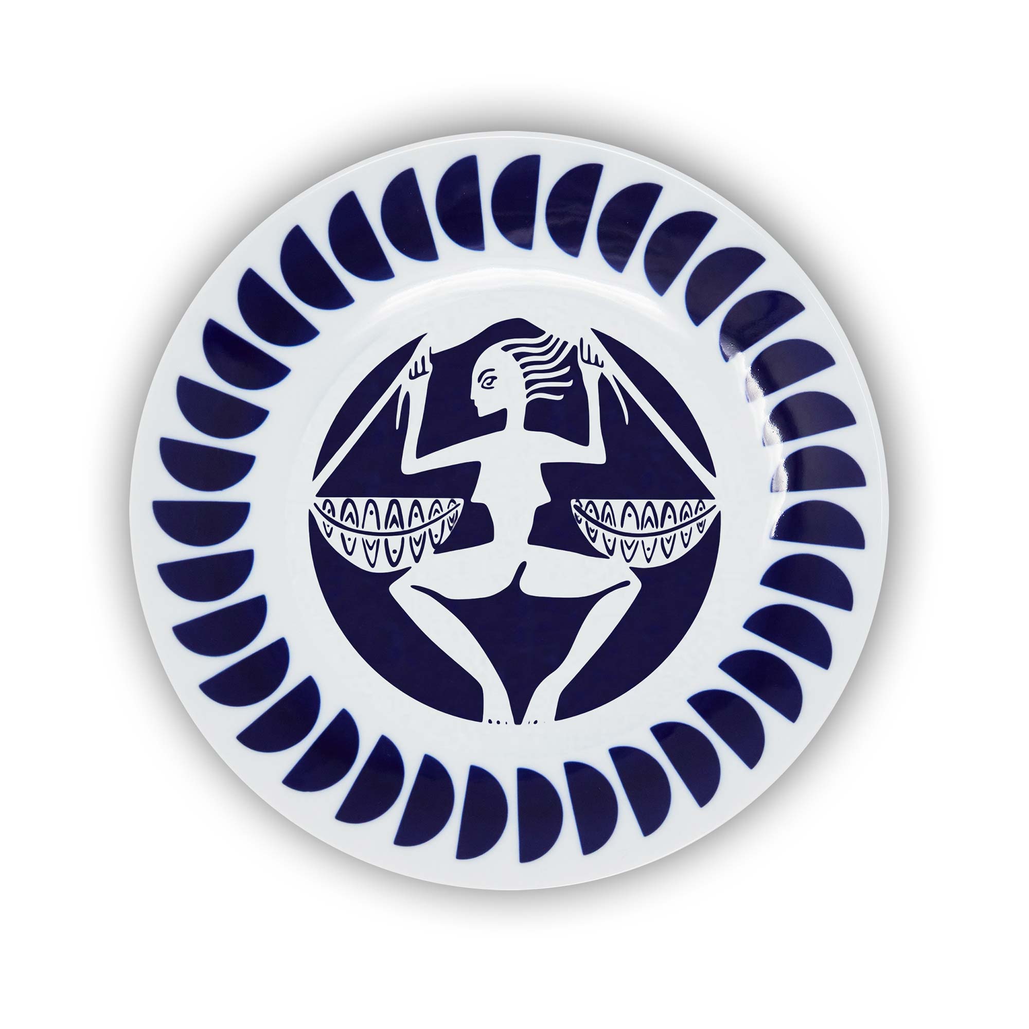 A round porcelain plate with a navy and white design featuring an illustration of the Libra sign of the zodiac.