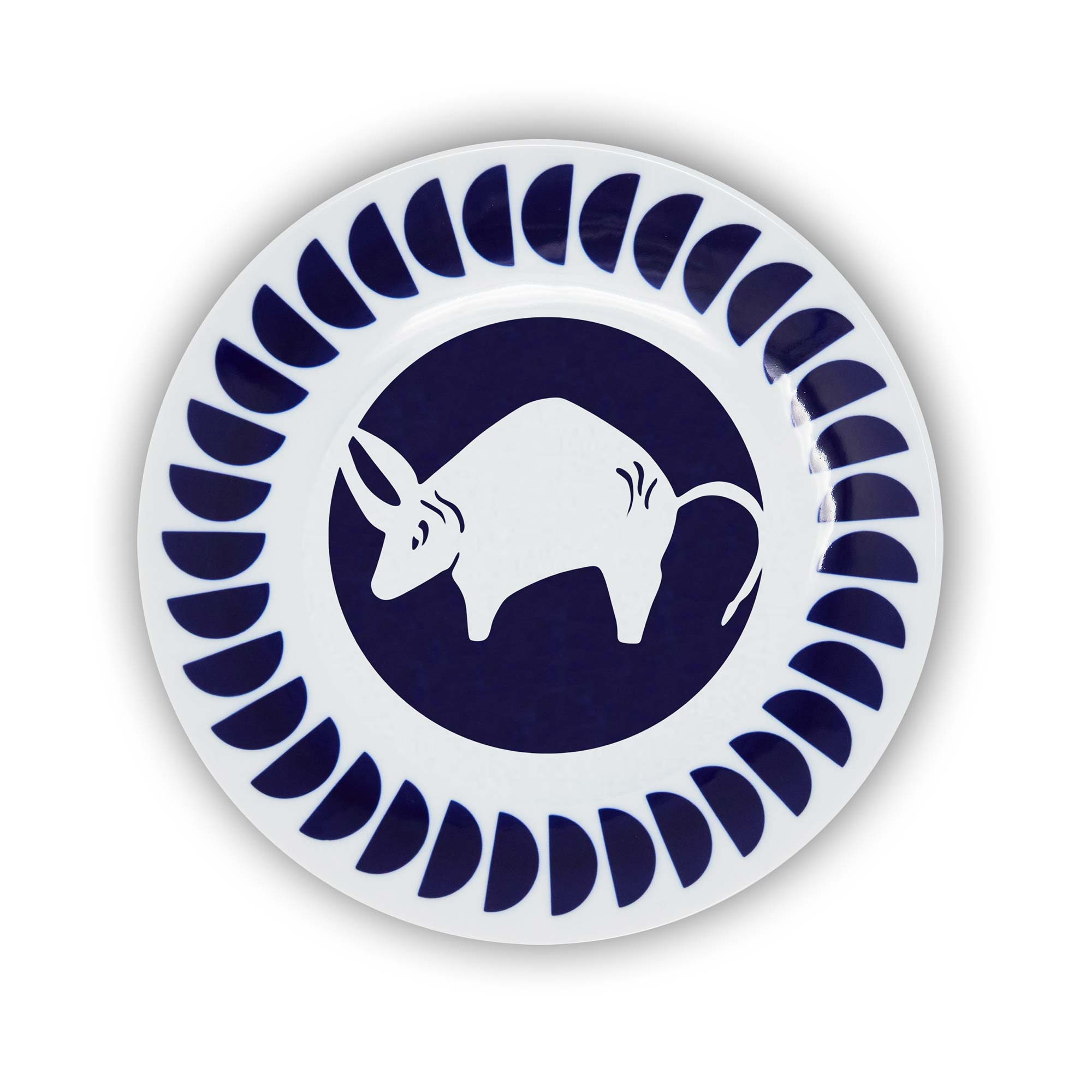 A round porcelain plate with a navy and white design featuring an illustration of the Taurus sign of the zodiac.