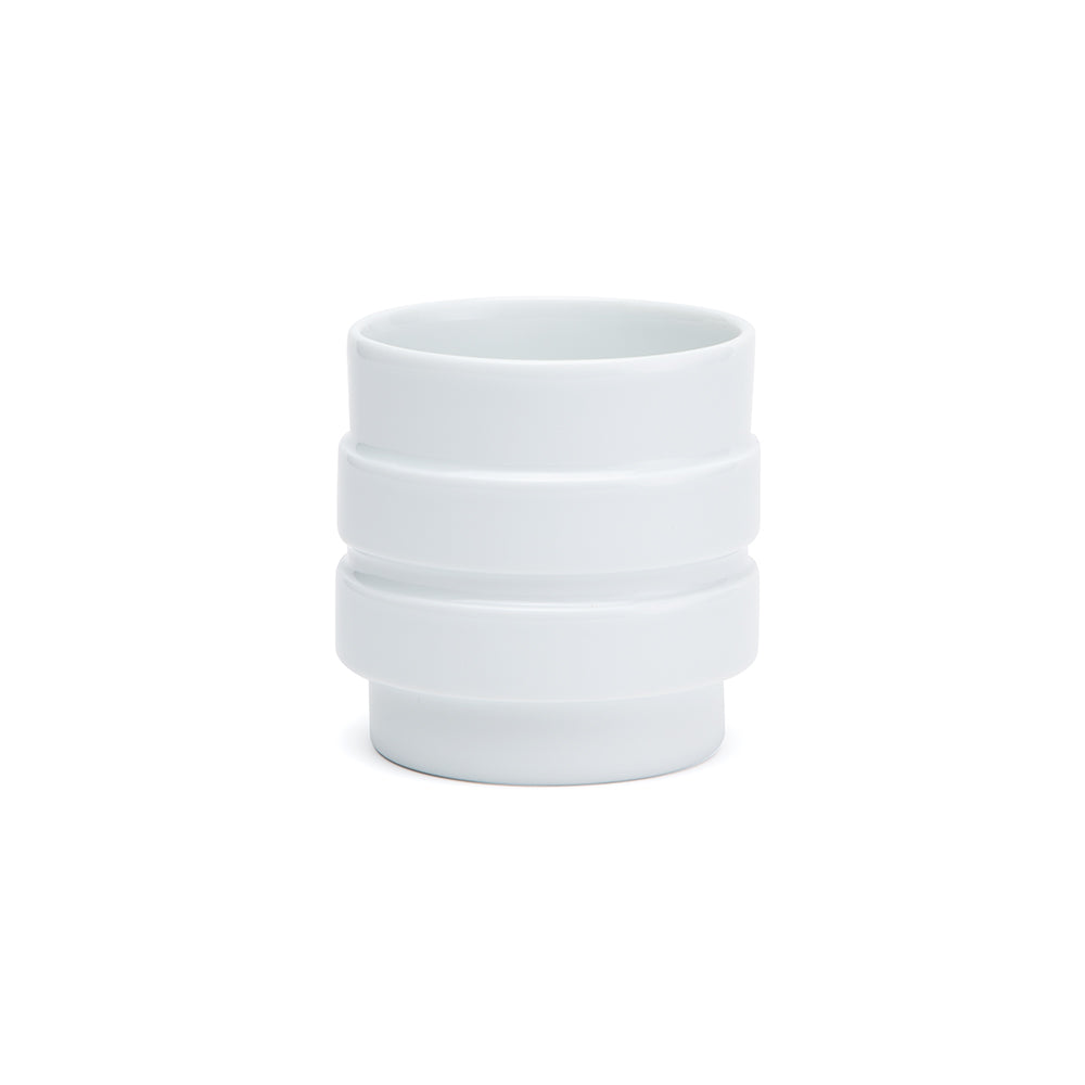 A white porcelain cup with a shape reminiscent of the various forms of nuts.