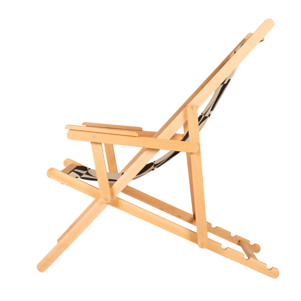 A folding beach chair with a geometric pattern in black and white, made of wood and cotton, displayed in a fully open position.
