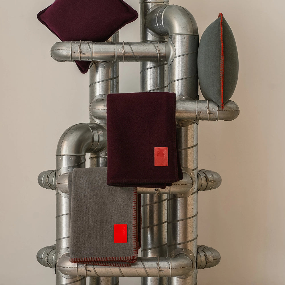 Metal pipes with merino blankets and pillows on a beige background
