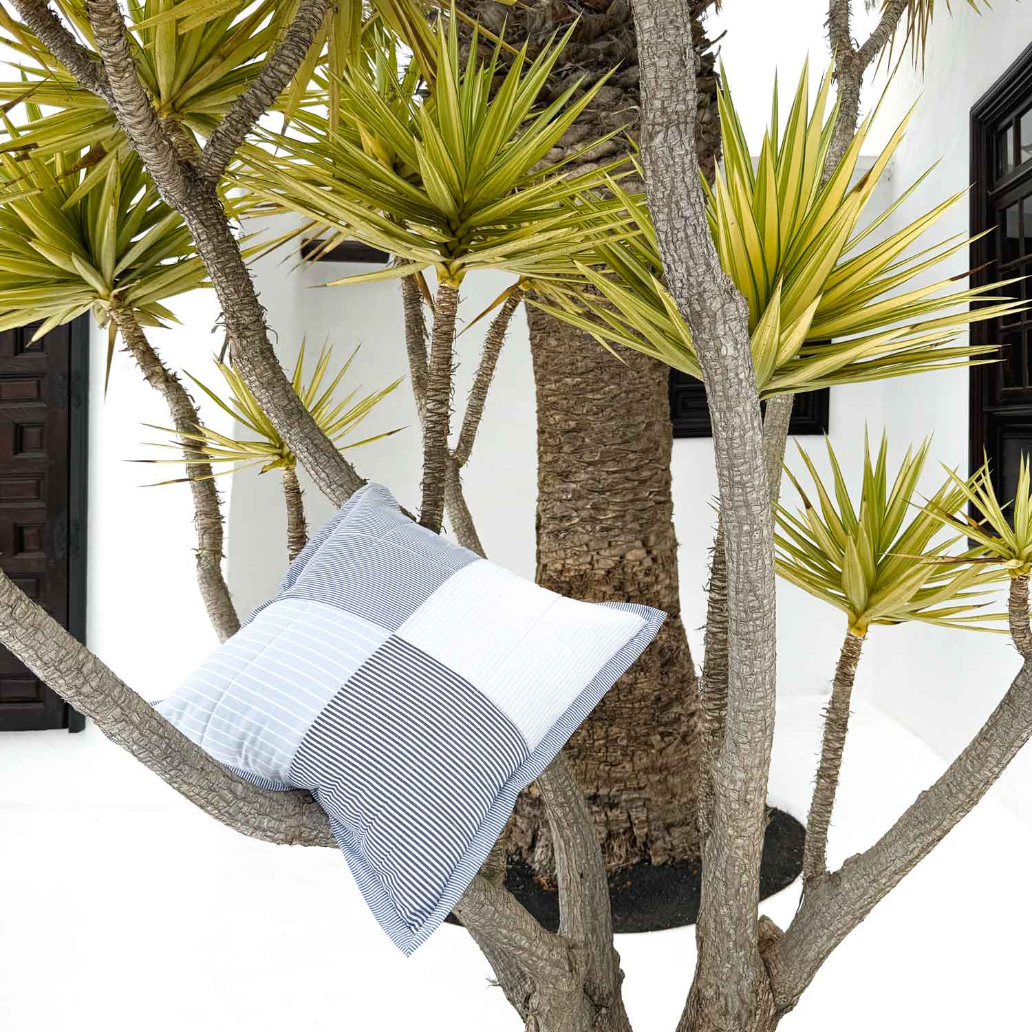 Decorative pillows on a branch with a tropical background