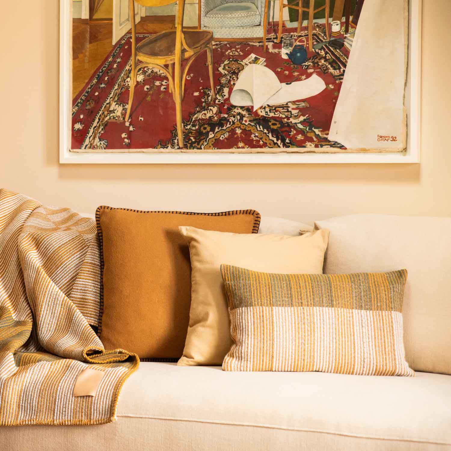 Close-up of pillows and blanket in shades of ochre and yellow on a sofa